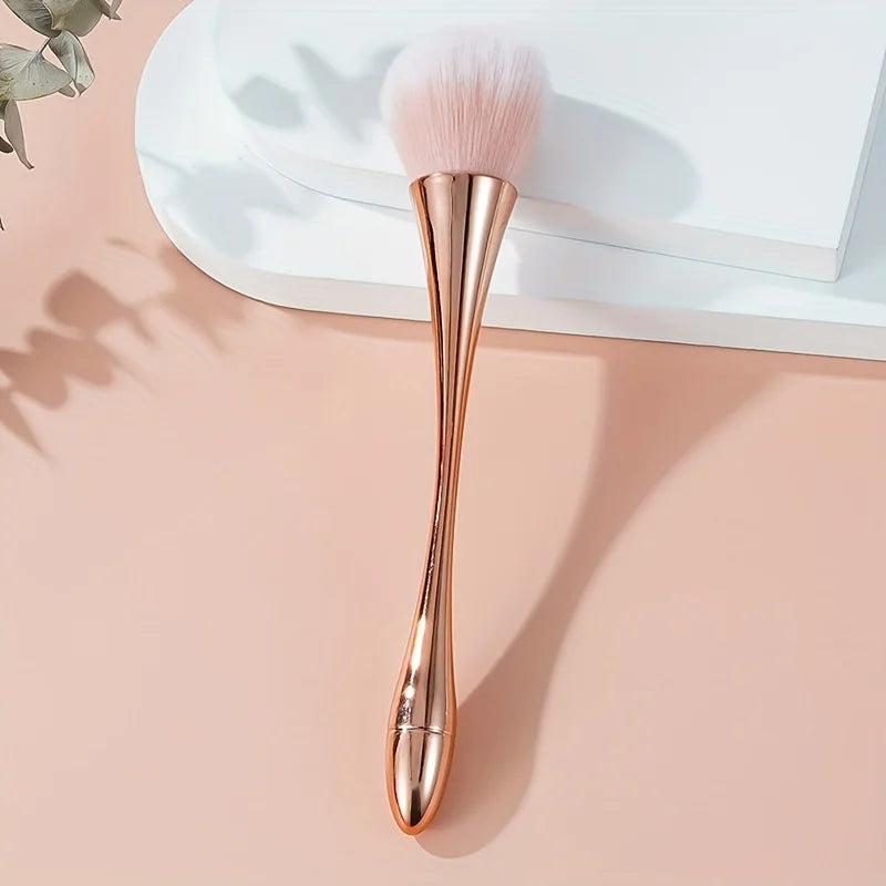 Rose gold fan brush with soft bristles, ideal for applying powder, highlighter, blush, and finishing touches