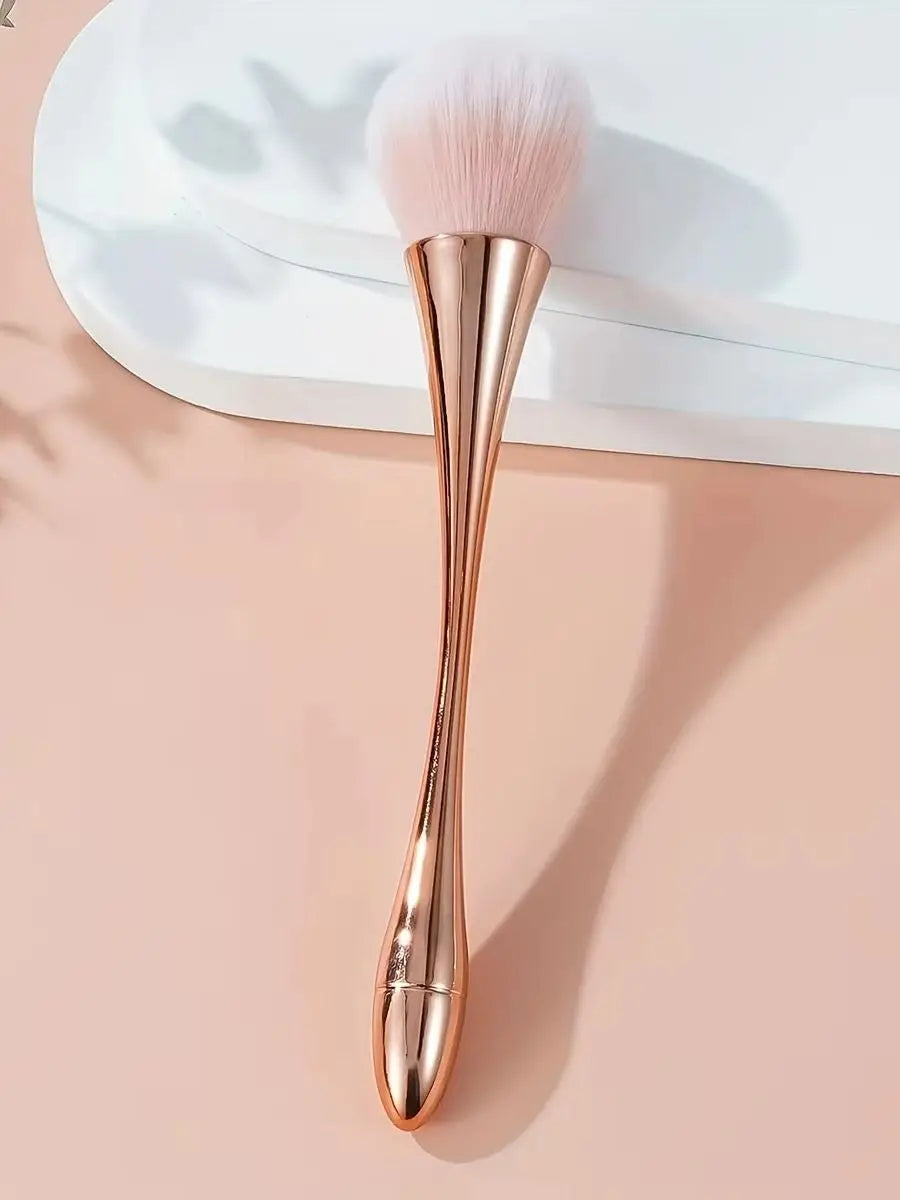 Rose gold fan brush with soft bristles, ideal for applying powder, highlighter, blush, and finishing touches