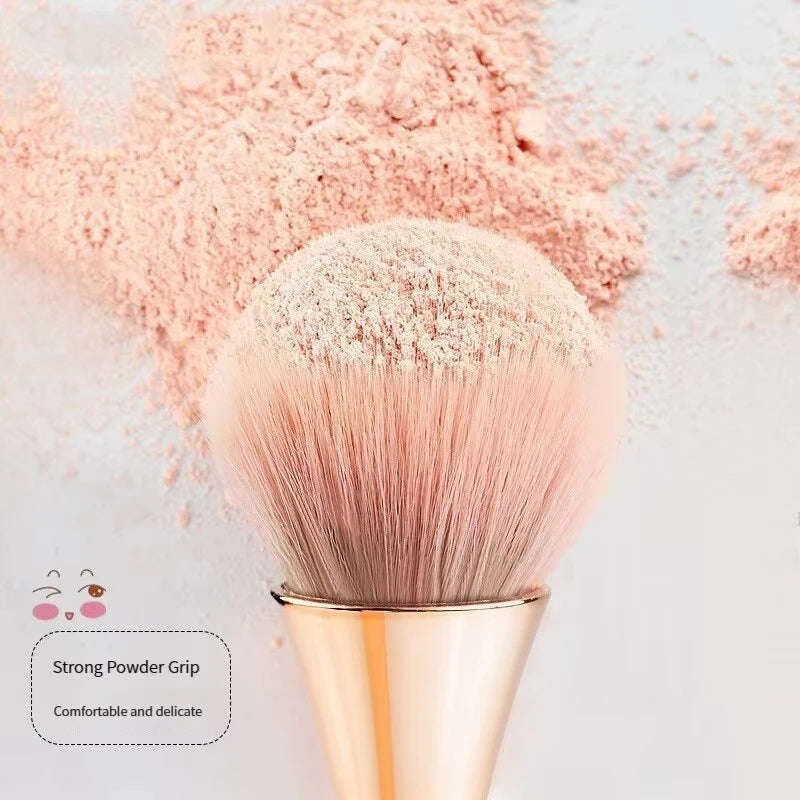 Rose gold fan brush with soft bristles, ideal for applying powder, highlighter, blush, and finishing touches